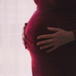 belly of pregnant woman in red dress