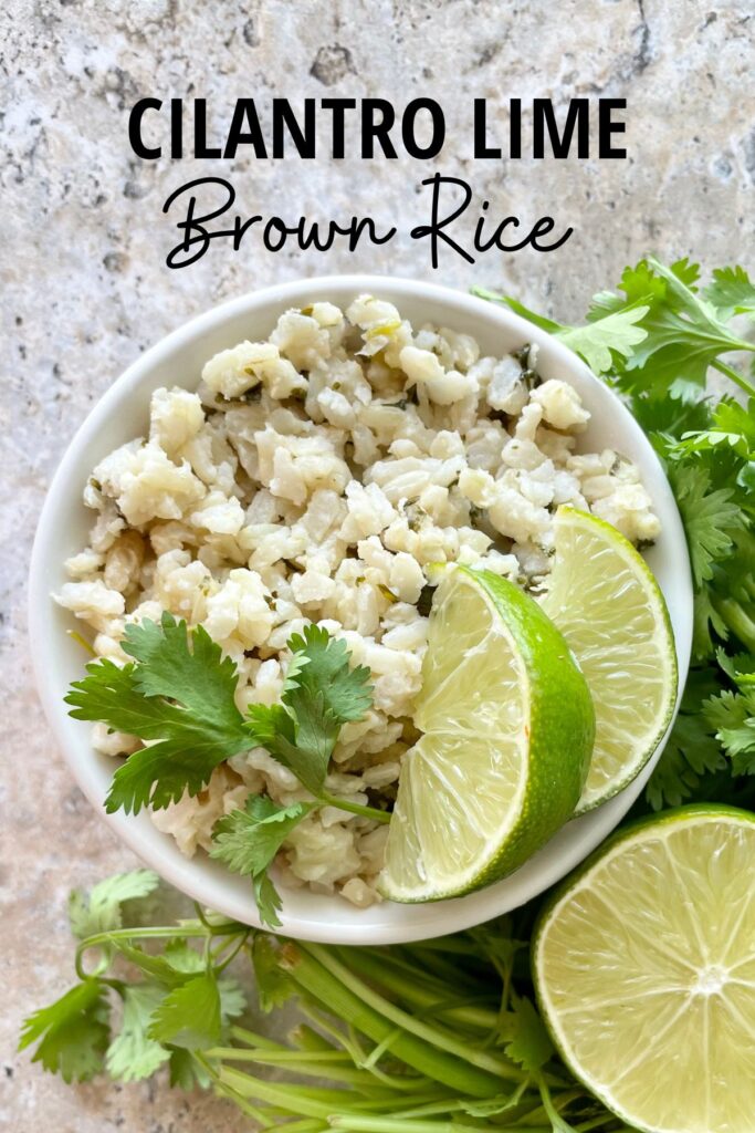 bowl of coconut cilantro lime brown rice with lime wedges and cilantro garnish