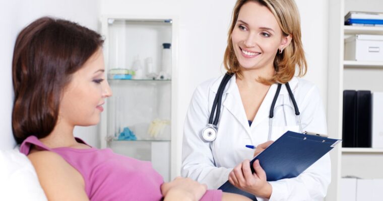 Pregnant woman talking to provider with clipboard